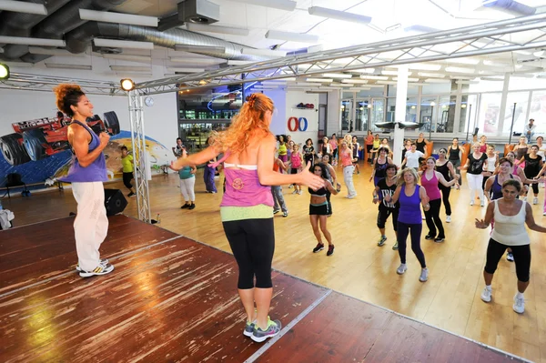 Gente bailando durante el entrenamiento de Zumba fitness en un gimnasio — Foto de Stock