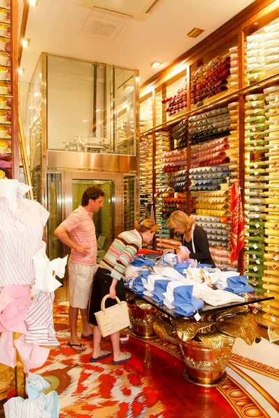 Продавец показывает текстиль покупателям в своем магазине — стоковое фото
