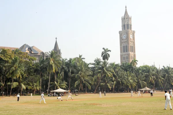 Gente jugando al cricket frente a la Torre Rajabai en Mumbai —  Fotos de Stock