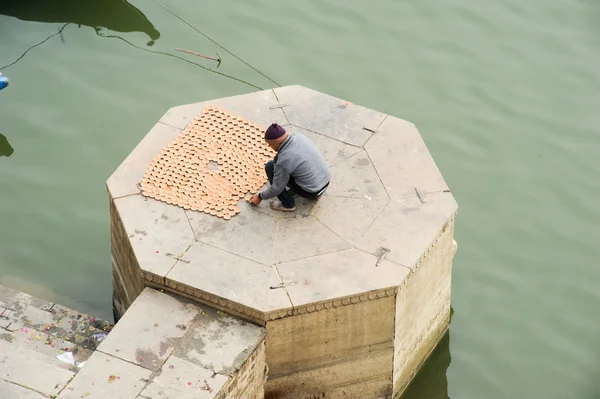 Hombre preparando ofertas en los Ghats del río Ganges — Foto de Stock