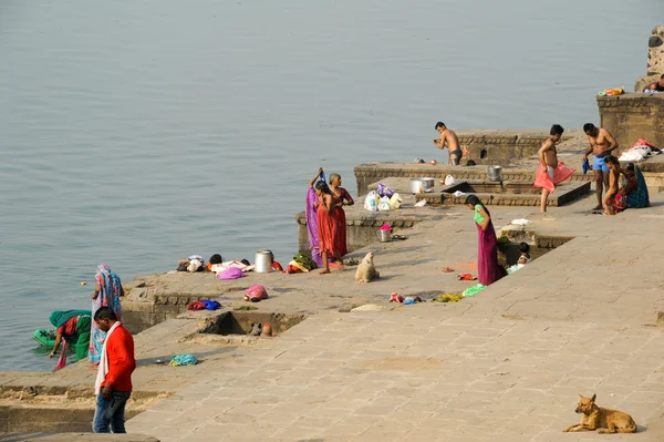 Folk tvättar kläder på heliga floden Narmada ghats på Maheshwa — Stockfoto