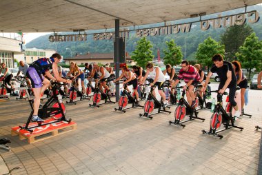 İnsanlar bir spinning dersi sırasında pedal