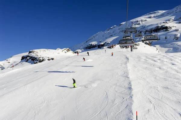 People skiing and going up the mountain by chairlift — Stock Photo, Image