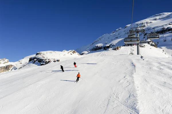 People skiing and going up the mountain by chairlift — Stock Photo, Image