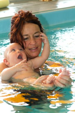 Bebek annesi ile bir havuzda yüzme keyfi