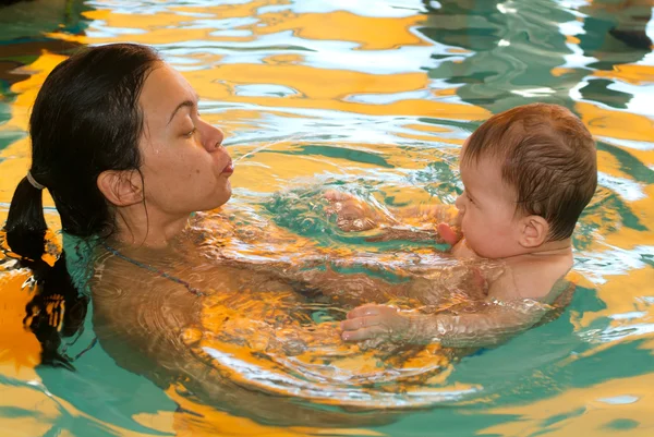 Bebek annesi ile bir havuzda yüzme keyfi