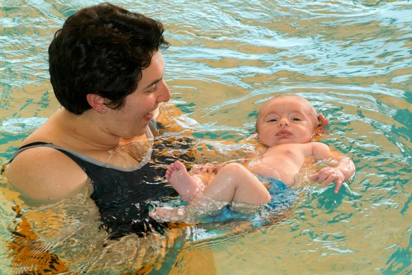 Schattige baby genieten van zwemmen in een zwembad met zijn moeder — Stockfoto