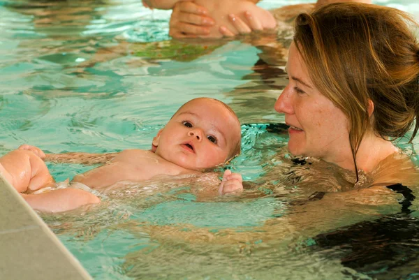 Schattige baby genieten van zwemmen in een zwembad met zijn moeder — Stockfoto