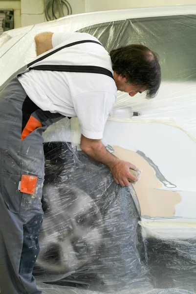 Mechanic reparing a car in auto repair shop — Stock Photo, Image