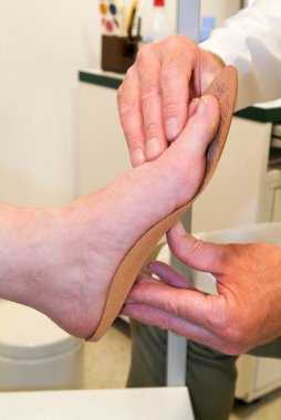 Doktor ortopedik tabanlık bir hasta için hazırlanıyor 
