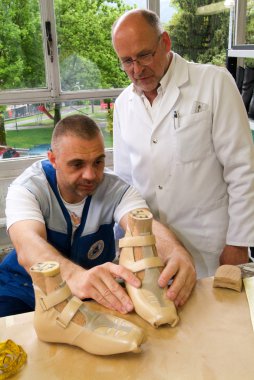 Doktor ve işçi ortopedik tabanlık bir hasta için hazırlanıyor