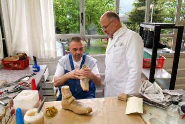 Doktor ve işçi ortopedik tabanlık bir hasta için hazırlanıyor