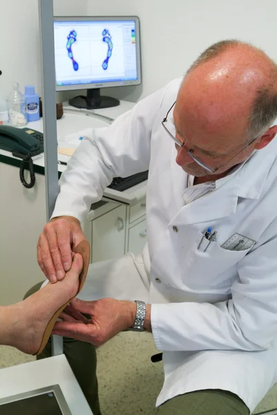 Doctor preparing orthopedic insoles for a patient on his studio — Stock Photo, Image