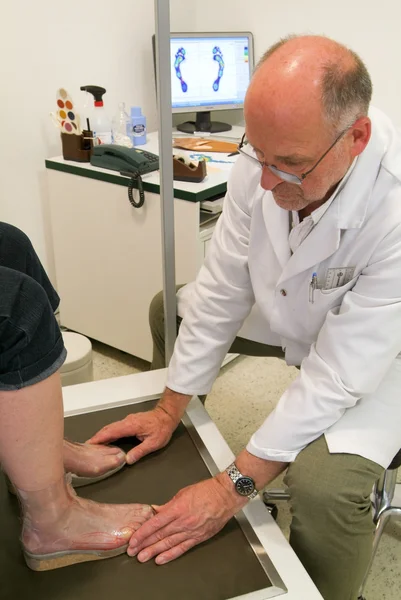 Doctor preparing orthopedic insoles for a patient on his studio — Stock Photo, Image