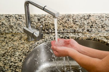 Kadın takeing su onun elinden bir musluk ile