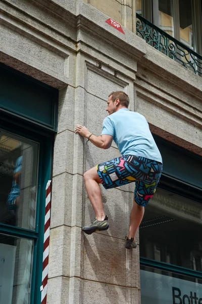 Uomo arrampicata una parete di casa su strada boulder contest — Foto Stock