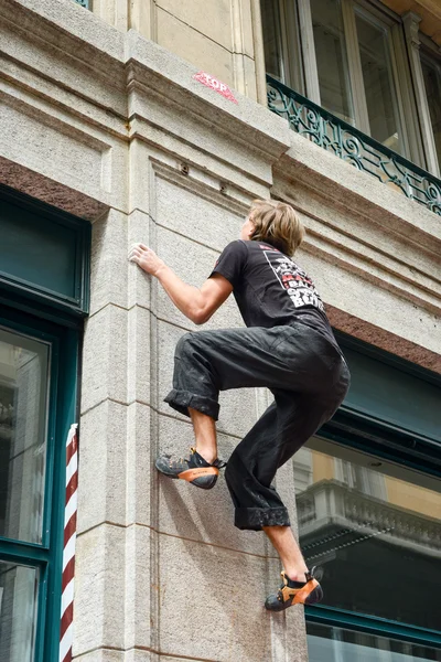 Hombre escalando una pared de la casa en la calle concurso de rocas —  Fotos de Stock