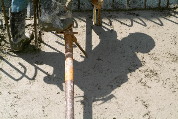 Вуличний працівник поливає цемент — стокове фото