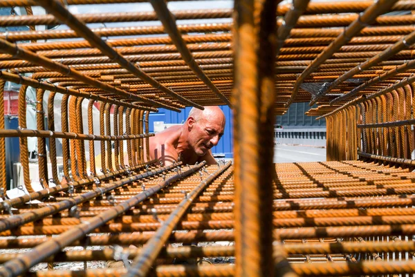 Trabalhador amarrando vergalhões para construção — Fotografia de Stock