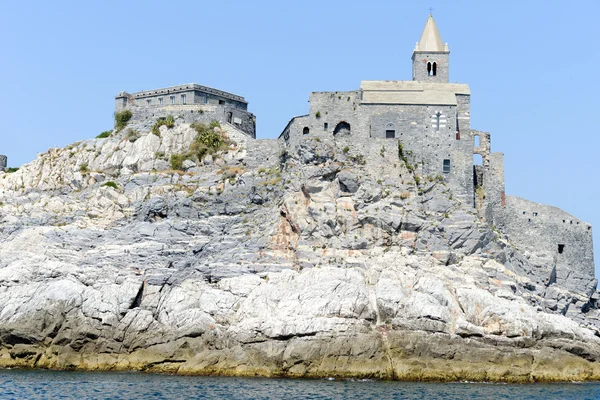 Gammel kirke på en steinete kystbredd – stockfoto
