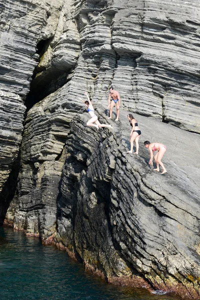 Людей, стрибки зі скелі в море на Вернацца — стокове фото