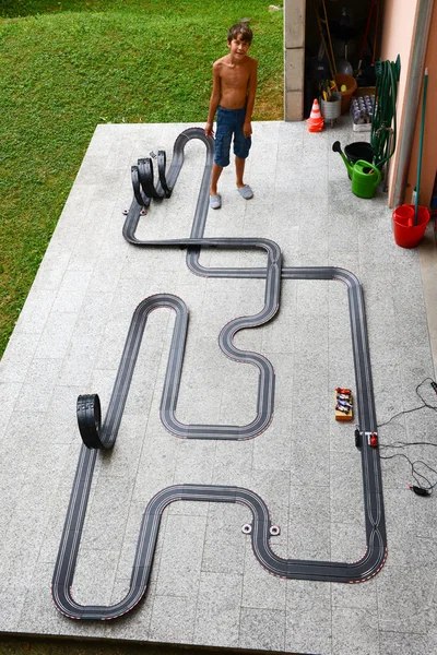 Boy playing with car racing track — Stock Photo, Image