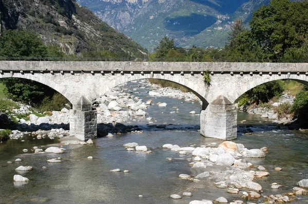 Old stone bridge over river Ticino at Biasca — Stock Photo, Image