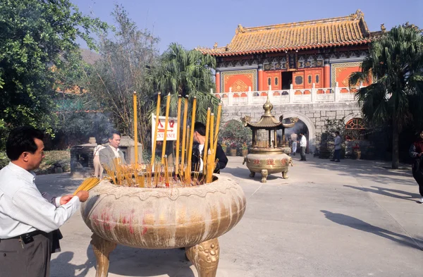 Des croyants bouddhistes brûlent de l'encens devant le monastère de Po Lin — Photo