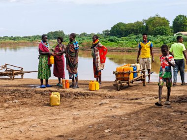 Kangaten, Etiyopya - 15 Ağustos 2025: Etiyopya 'nın Kangaten kentindeki Omo nehrinde su alan bir grup insan