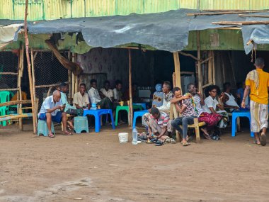 Afdera, Etiyopya - 20 Ağustos 2025: Etiyopya 'da Afdera' nın çamurlu sokaklarında yürüyen insanlar