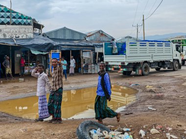 Afdera, Etiyopya - 20 Ağustos 2025: Etiyopya 'da Afdera' nın çamurlu sokaklarında yürüyen insanlar