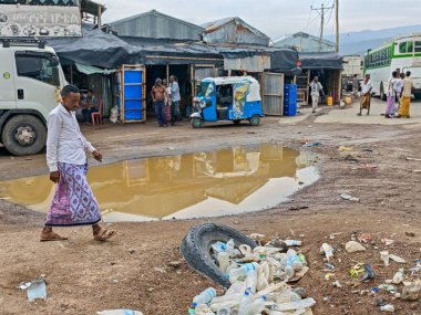 Afdera, Etiyopya - 20 Ağustos 2025: Etiyopya 'da Afdera' nın çamurlu sokaklarında yürüyen insanlar