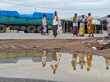 Afdera, Etiyopya - 20 Ağustos 2025: Etiyopya 'da Afdera' nın çamurlu sokaklarında yürüyen insanlar