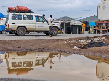 Afdera, Etiyopya - 20 Ağustos 2025: Etiyopya 'da Afdera' nın çamurlu sokaklarında yürüyen insanlar