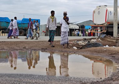 Afdera, Etiyopya - 20 Ağustos 2025: Etiyopya 'da Afdera' nın çamurlu sokaklarında yürüyen insanlar