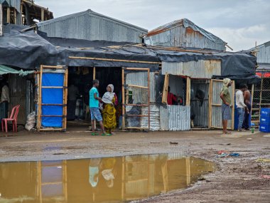 Afdera, Etiyopya - 20 Ağustos 2025: Etiyopya 'da Afdera' nın çamurlu sokaklarında yürüyen insanlar