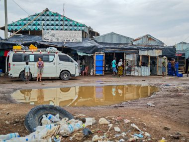 Afdera, Etiyopya - 20 Ağustos 2025: Etiyopya 'da Afdera' nın çamurlu sokaklarında yürüyen insanlar