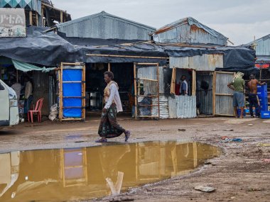 Afdera, Etiyopya - 20 Ağustos 2025: Etiyopya 'da Afdera' nın çamurlu sokaklarında yürüyen insanlar