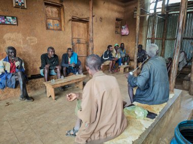 Konso, Etiyopya - 16 Ağustos 2025: Etiyopya 'nın Konso köyünde oturan ve konuşan yaşlı adam