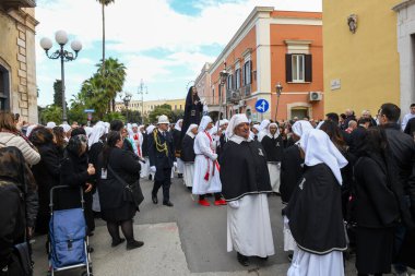 Bisceglie, İtalya - 18 Nisan 2025: Paskalya geçişleri sırasında Bisceglie sokaklarında yürüyen insanlar