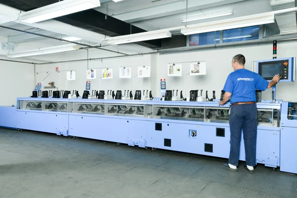 Hombre trabajando en una máquina de proceso de costura de folleto y revista —  Fotos de Stock