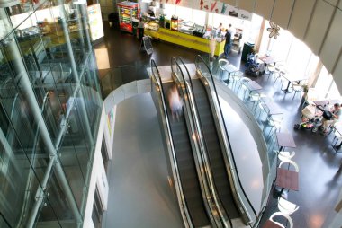 İnsanlar yürüyen merdiven üzerinde hareket