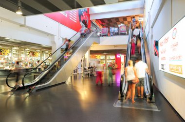 İnsanlar yürüyen merdiven üzerinde hareket