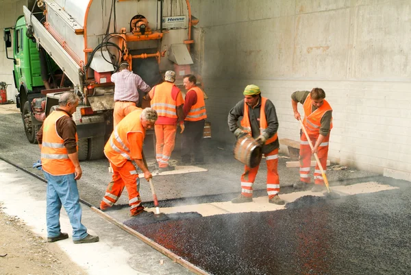 Travailleurs et véhicules pendant l'asphaltage de la route — Photo