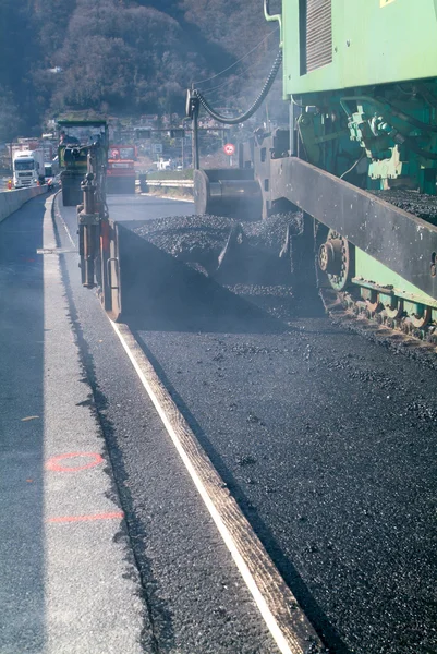 Travailleurs et véhicules pendant l'asphaltage de la route — Photo