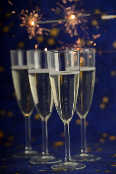 Glasses with champagne against holiday lights — Stock Photo, Image