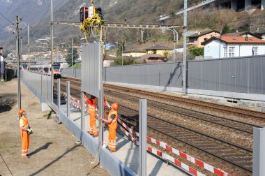 Workers during the installation of noise barriers on the railway clipart
