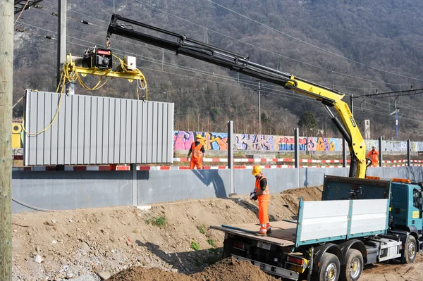 Trabajadores durante la instalación de barreras acústicas en el ferrocarril — Foto de Stock