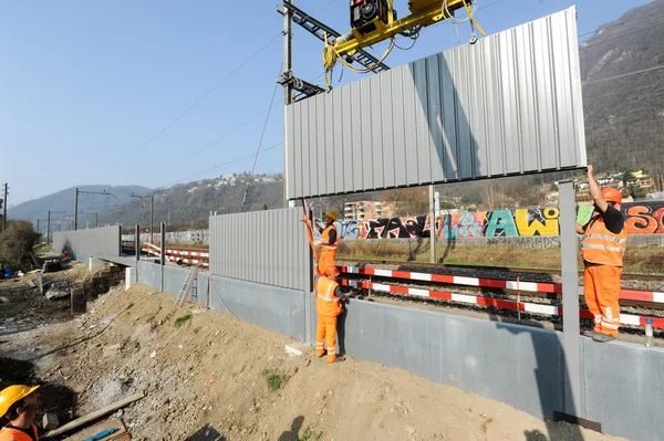 Werknemers tijdens de installatie van lawaai belemmeringen op de railway — Stockfoto