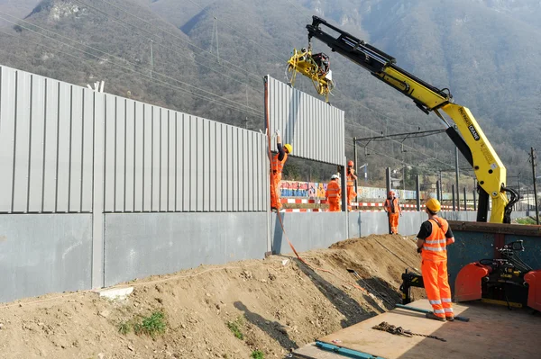 Trabajadores durante la instalación de barreras acústicas en el ferrocarril — Foto de Stock